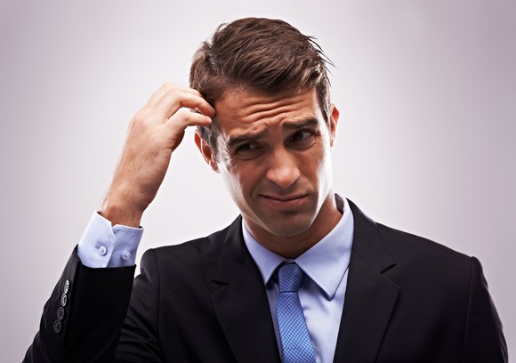 Man with a quizzical look scratching his head.