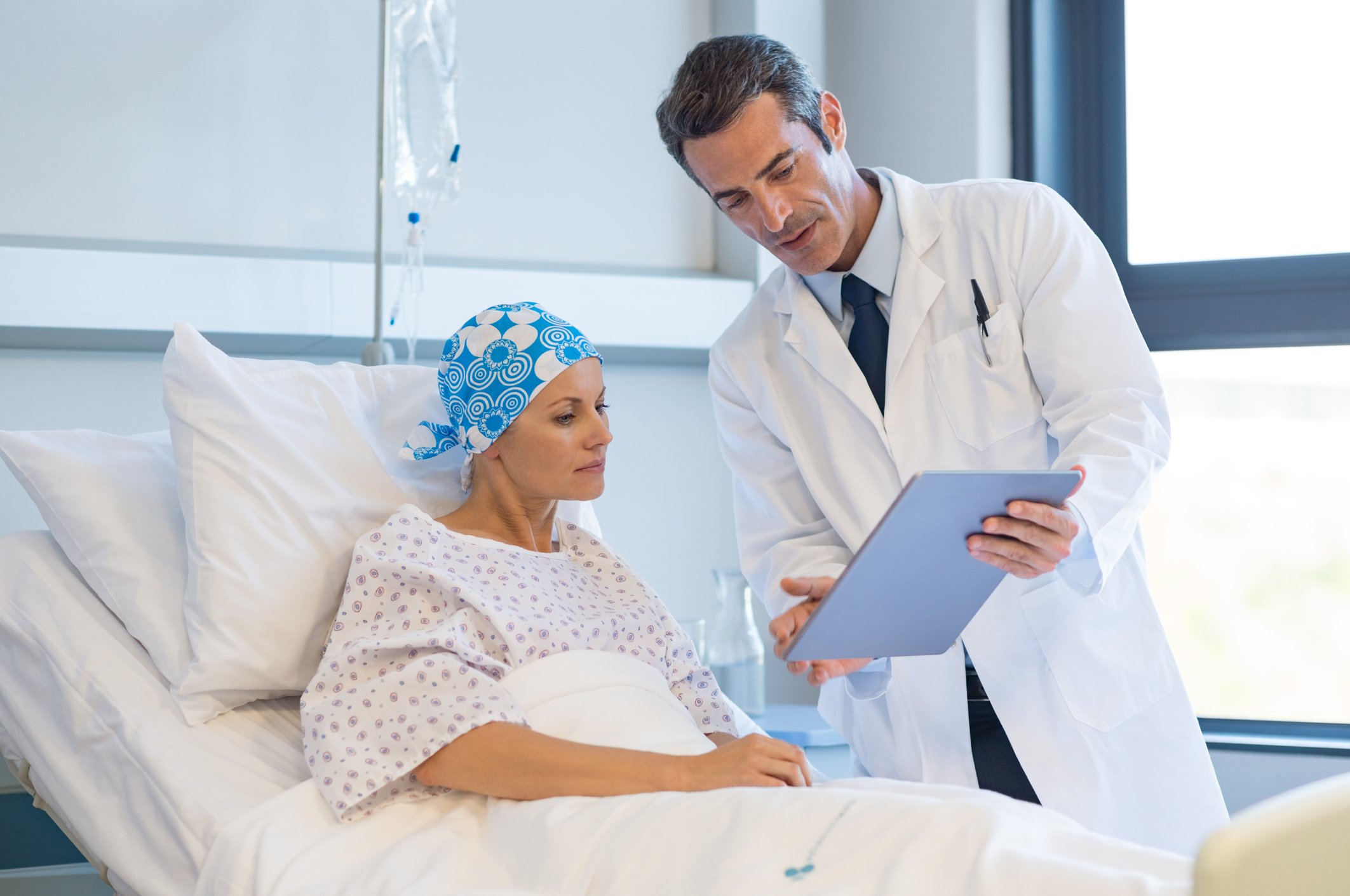 Cancer patient speaking with doctor in hospital.