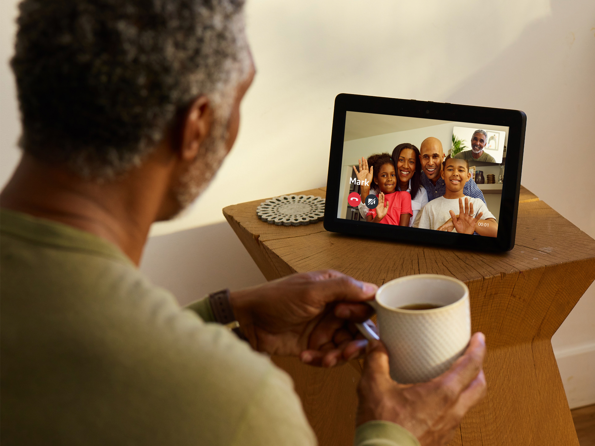 Man using an Echo Show device to talk to family members. 
