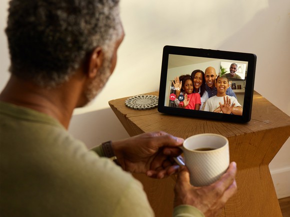 Man using an Echo Show device to talk to family members. 