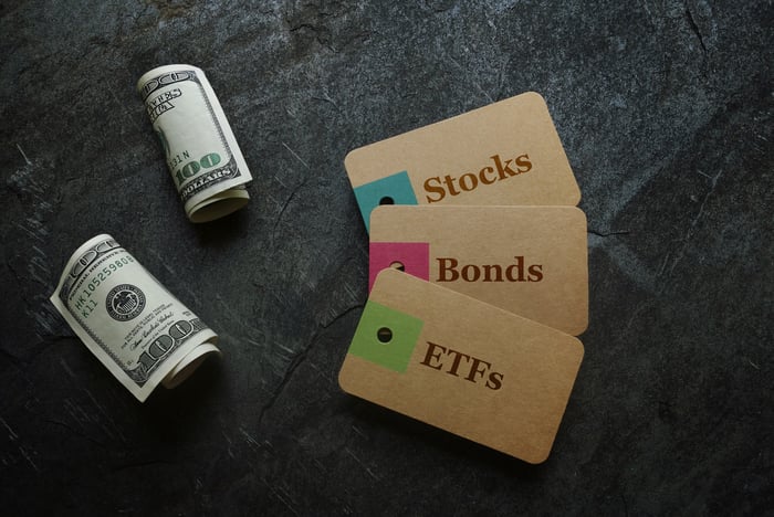 WOrds stocks bonds and ETFs writting on blocks next to bills