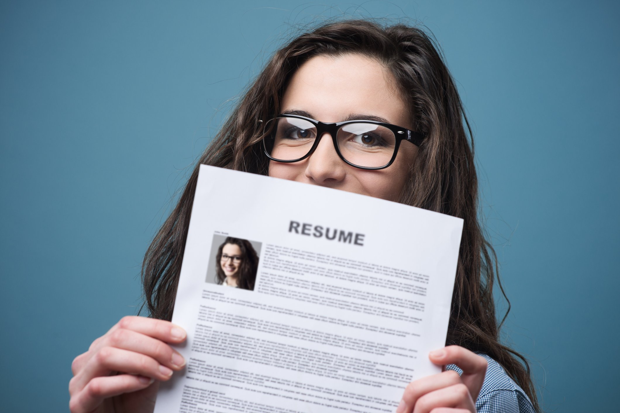 Woman holding up a resume.