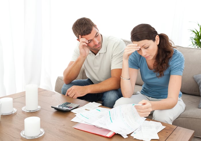 Couple looking at documents and appearing concerned.