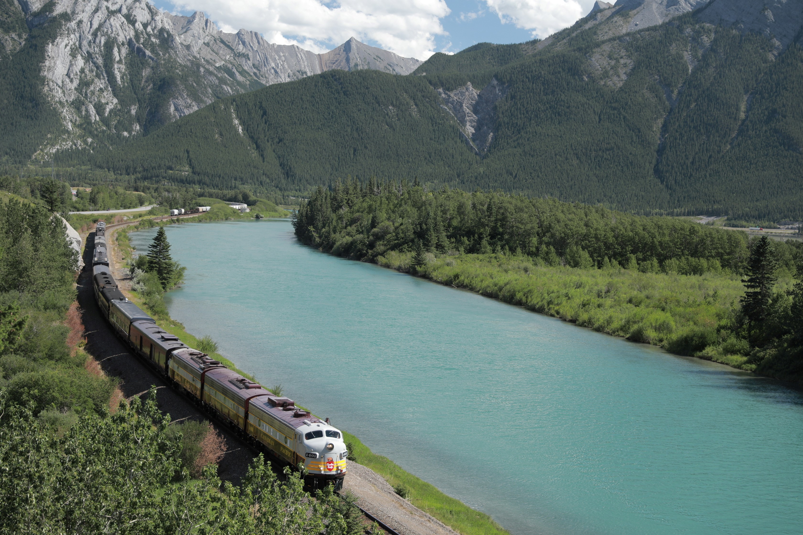 Locomotive moving along tracks next to a river.