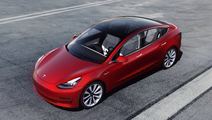 A red Tesla Model 3 Performance, a high-performance version of the compact electric luxury sedan.