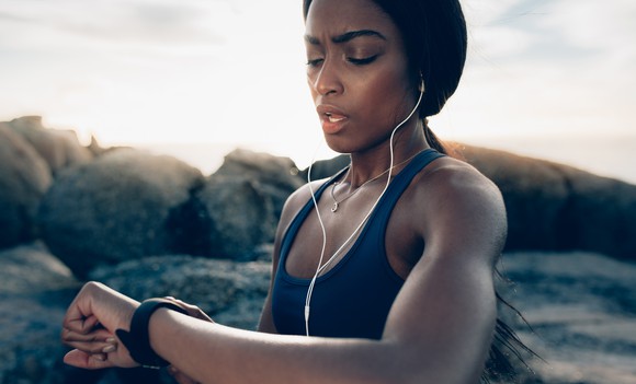 A woman checks her smartwatch while working out.