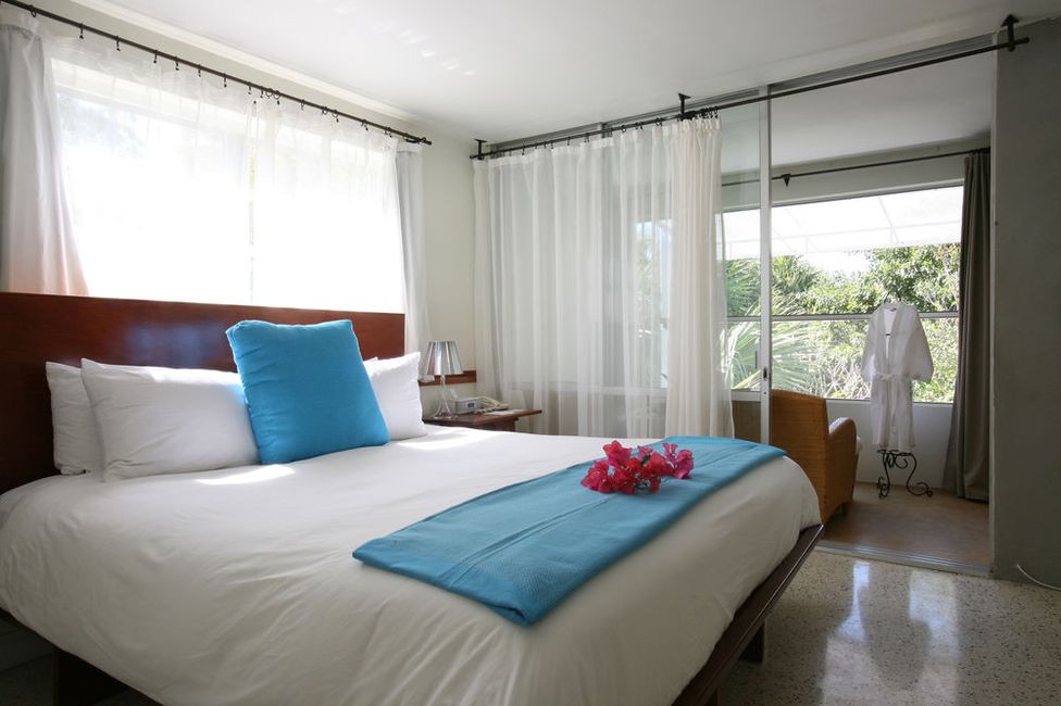 A bed in a hotel room with a terrace in the background.