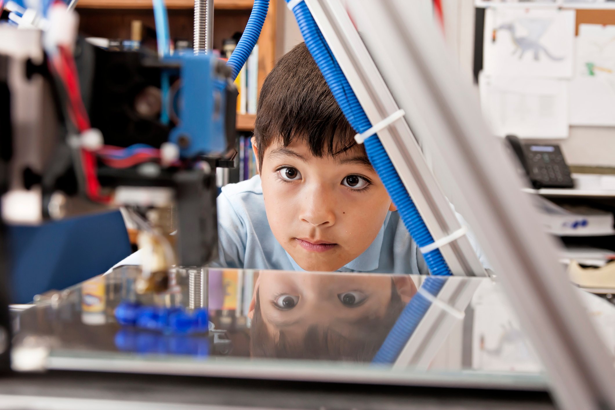 Child watching a 3D printer at work
