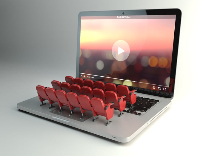 Small toy movie theater chairs face a laptop screen