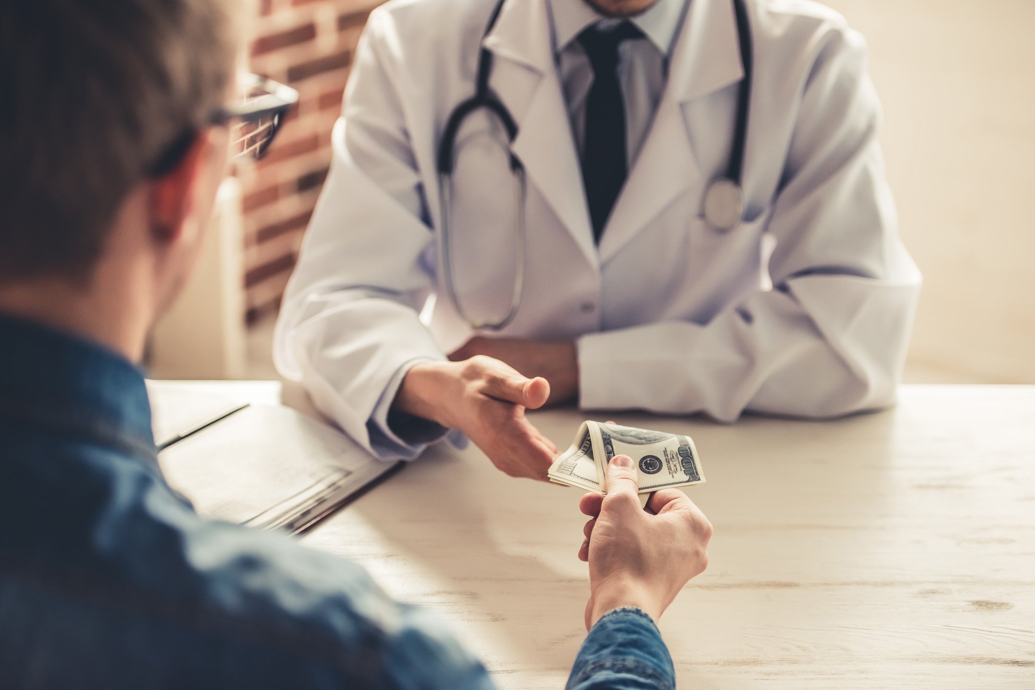 Person handing money to a doctor.
