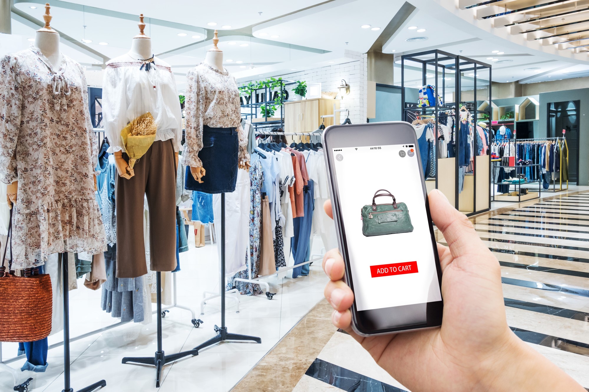 A person using a smartphone in a clothing store.