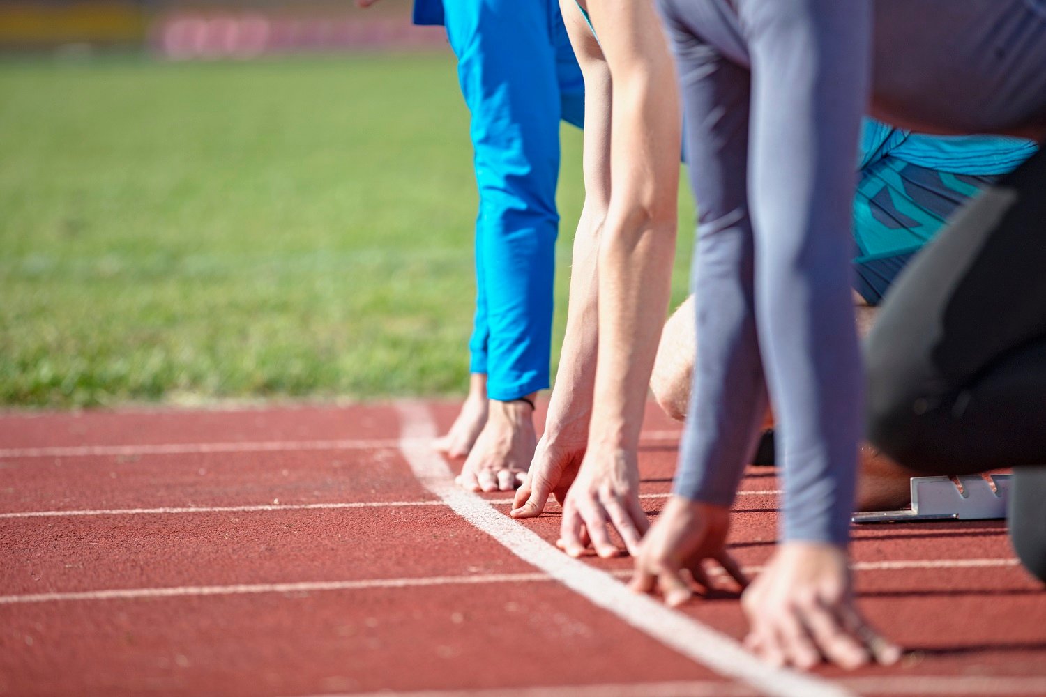 Runners kneeling at the starting line.