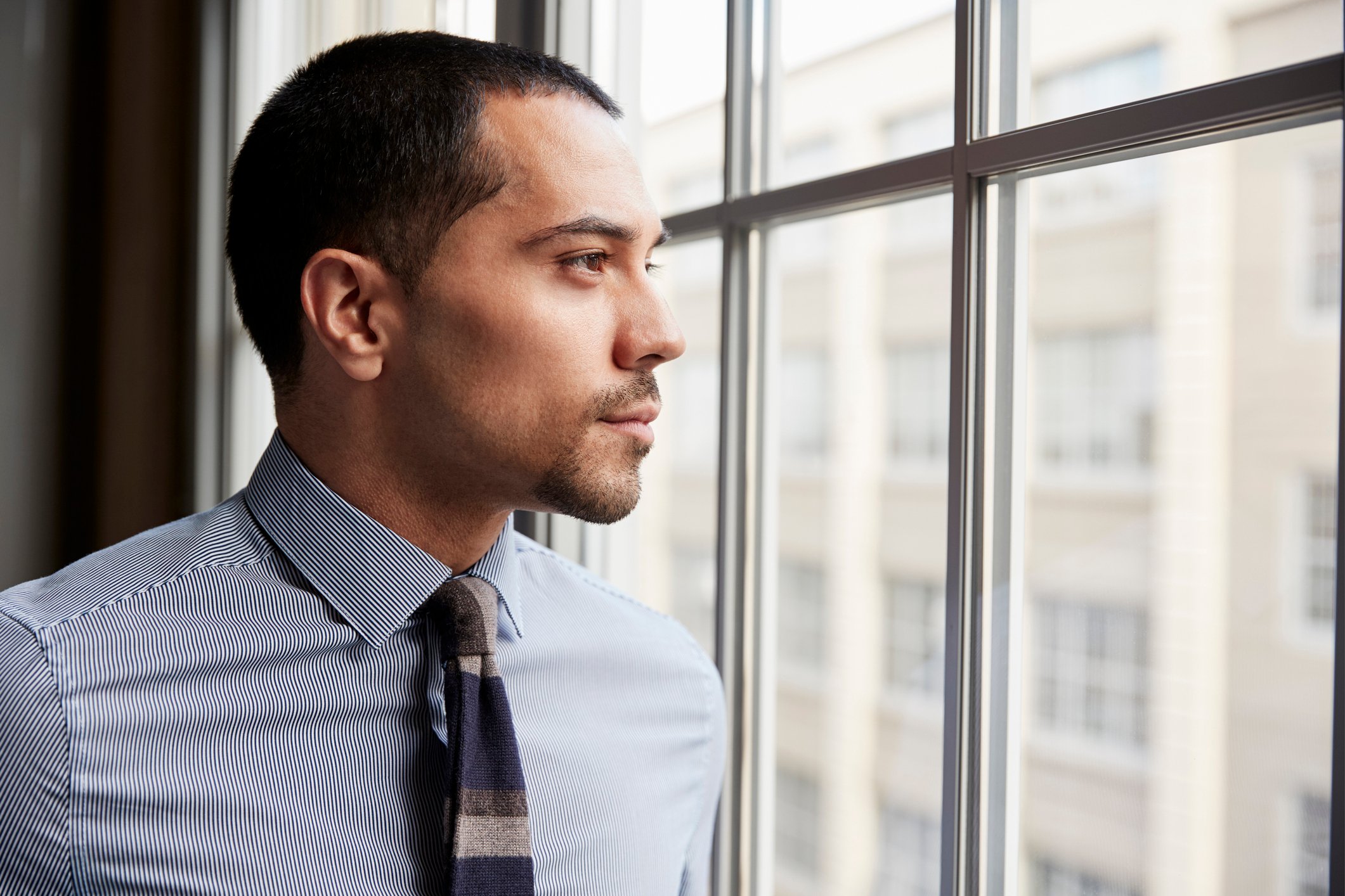 Professionally dressed man looking out a window