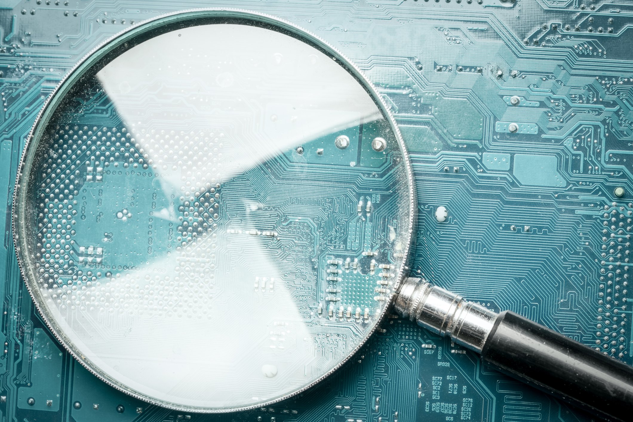 A magnifying glass laid on top of a circuit board.