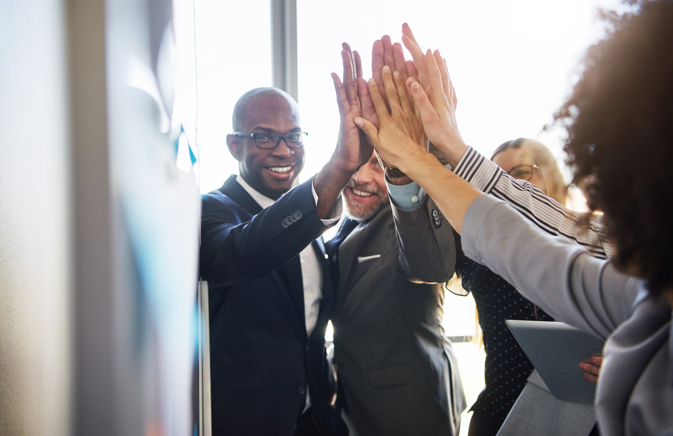 Team of businesspeople giving high fives.