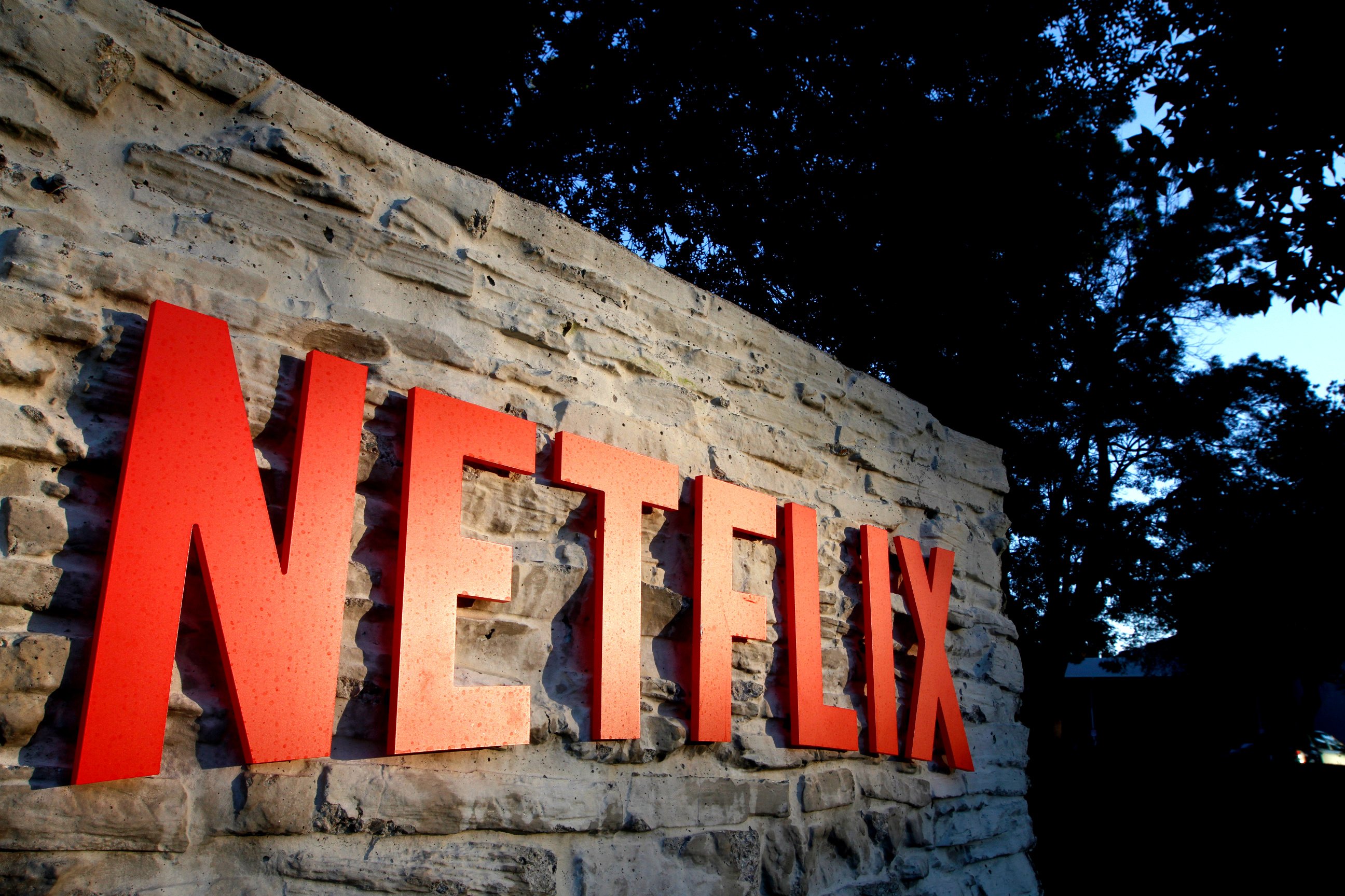 A red Netflix logo on a rock wall outside the company's headquarters in Los Gatos, California.