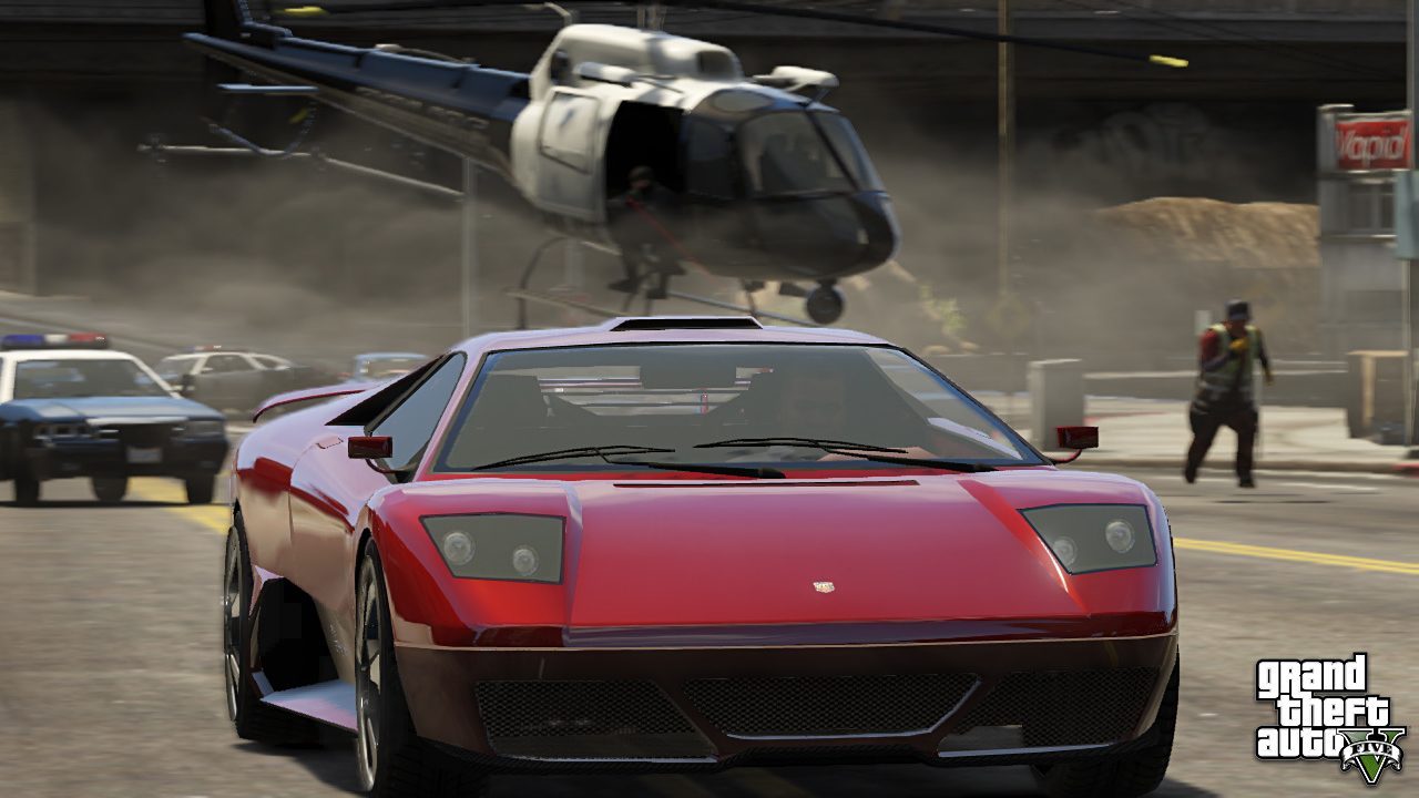 A red sports car being pursued by police cars and a helicopter in a scene from video game "Grand Theft Auto 5."