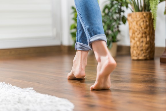 Woman walking on hardwood floor.