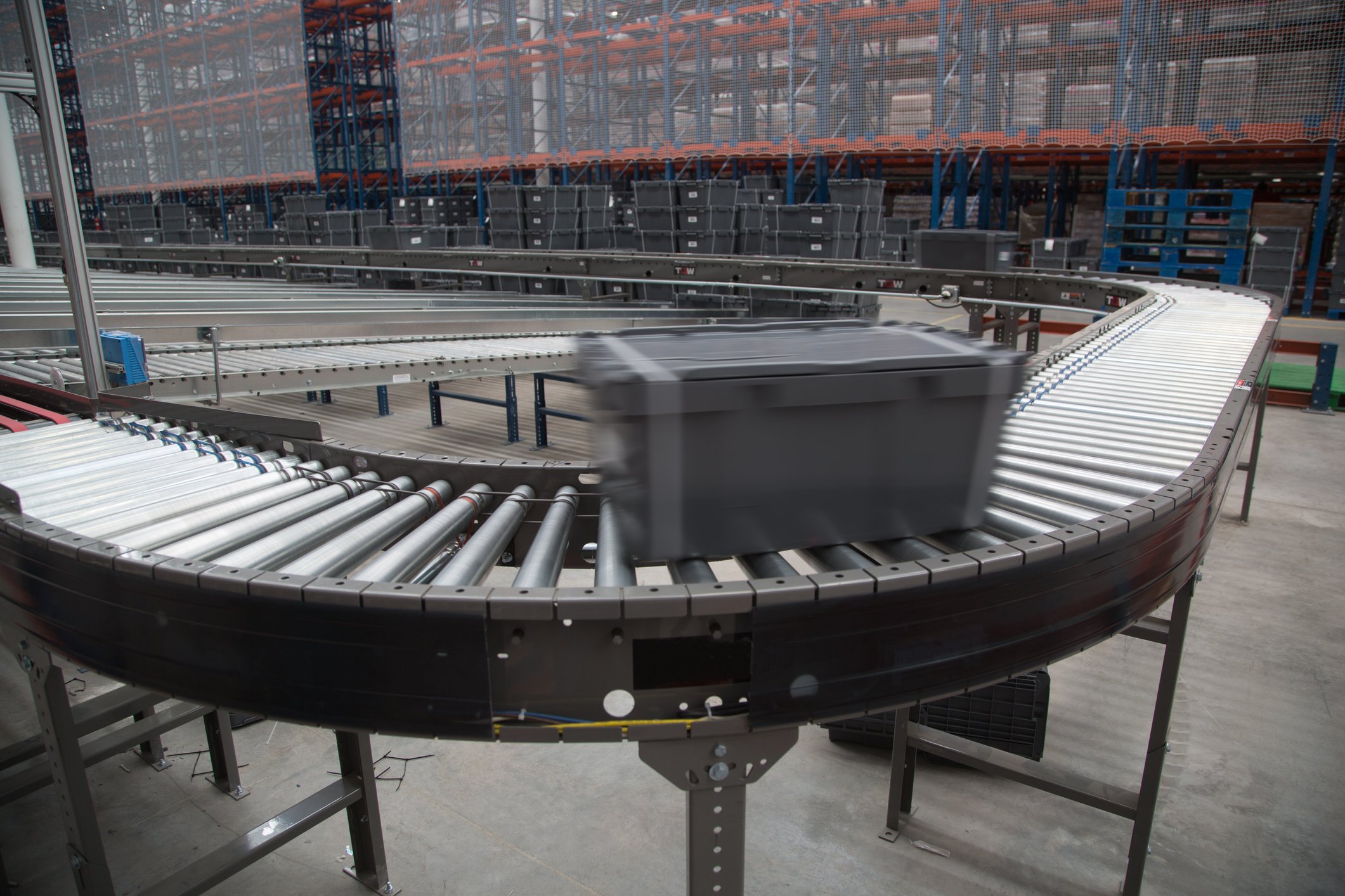A bin moves on a conveyor belt in a warehouse