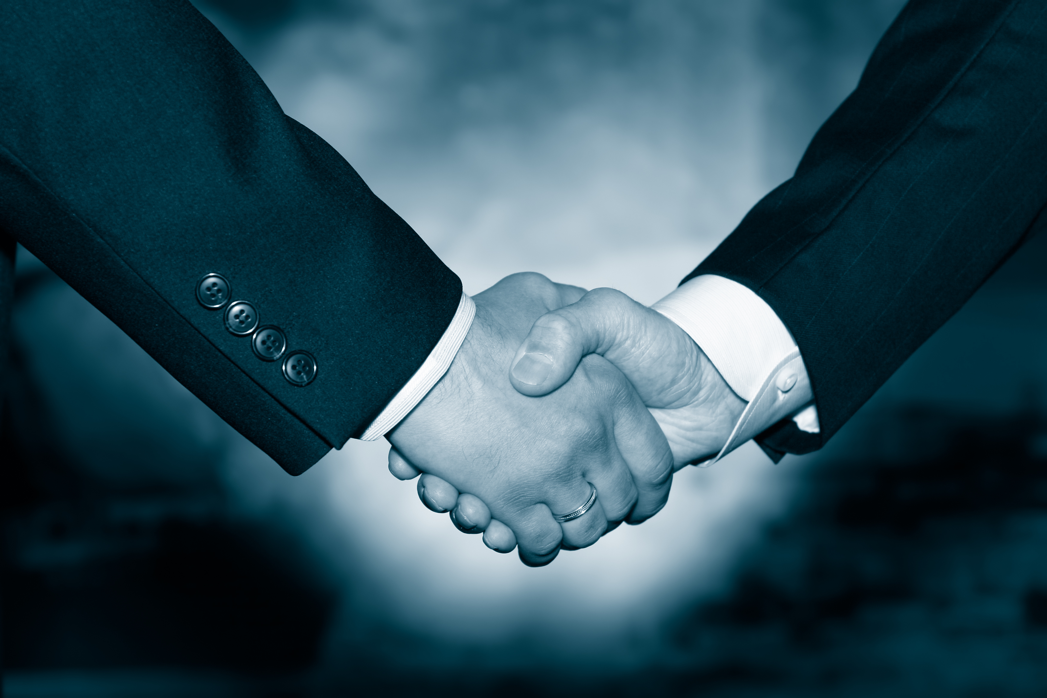 Two businessmen shaking hands, as if in agreement. 