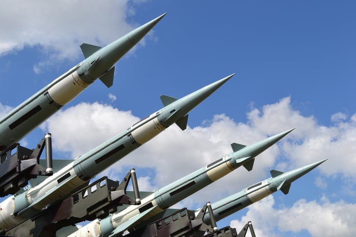 4 rockets lined up against a blue sky.