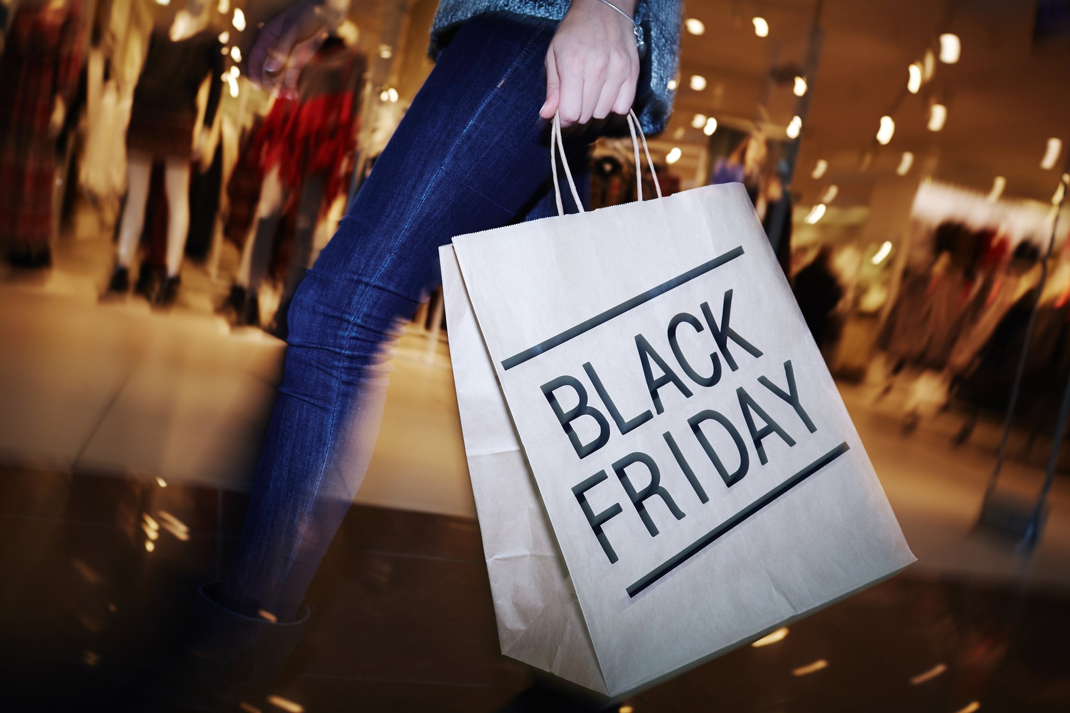 A person carries a shopping bag that has the words Black Friday on it.