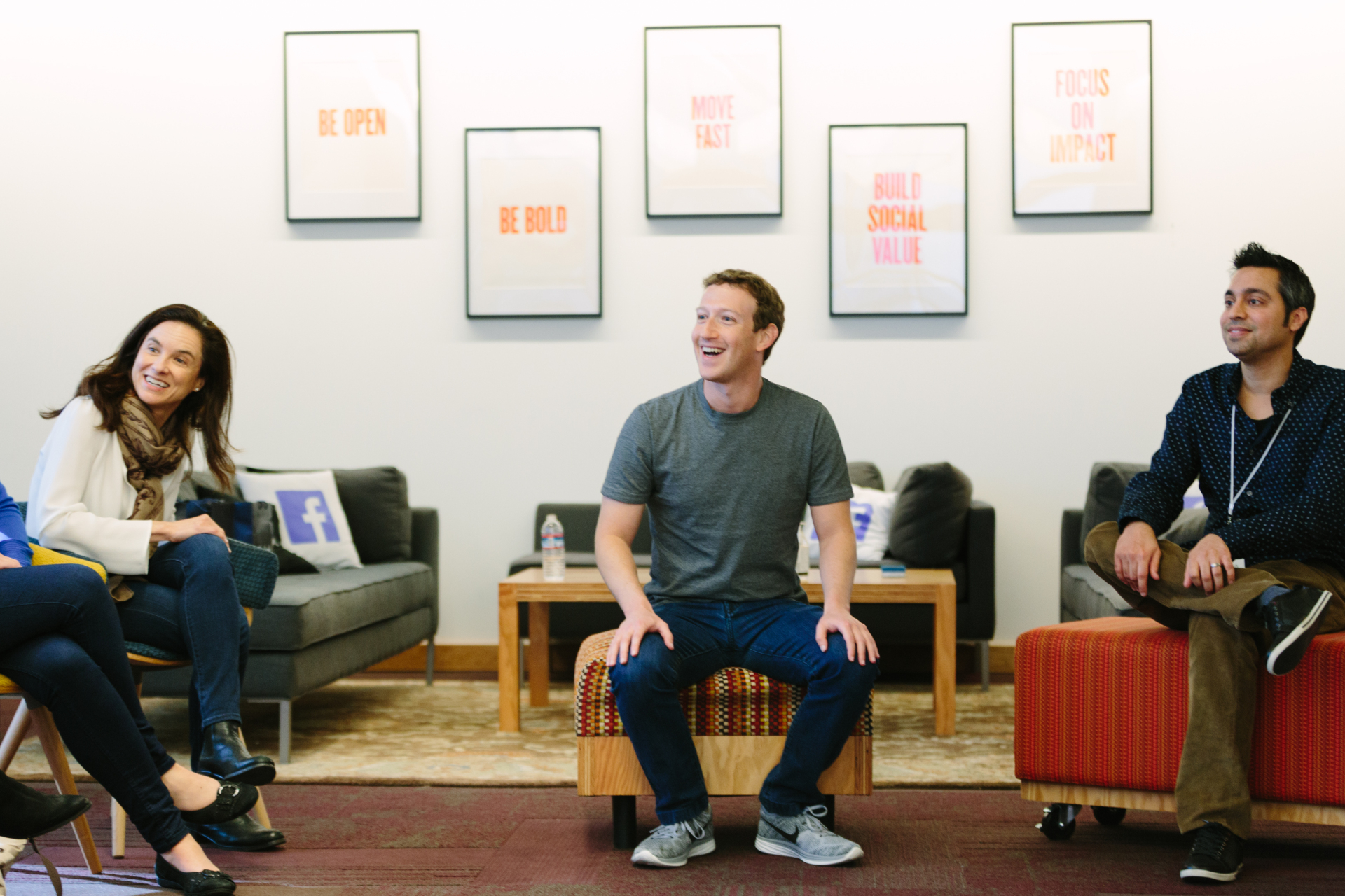 CEO Mark Zuckerberg sitting with three colleagues in an office, with all of them smiling.