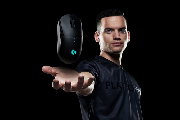 A man holding out his hand with a Logitech wireless gaming mouse hovering above the palm of his hand.