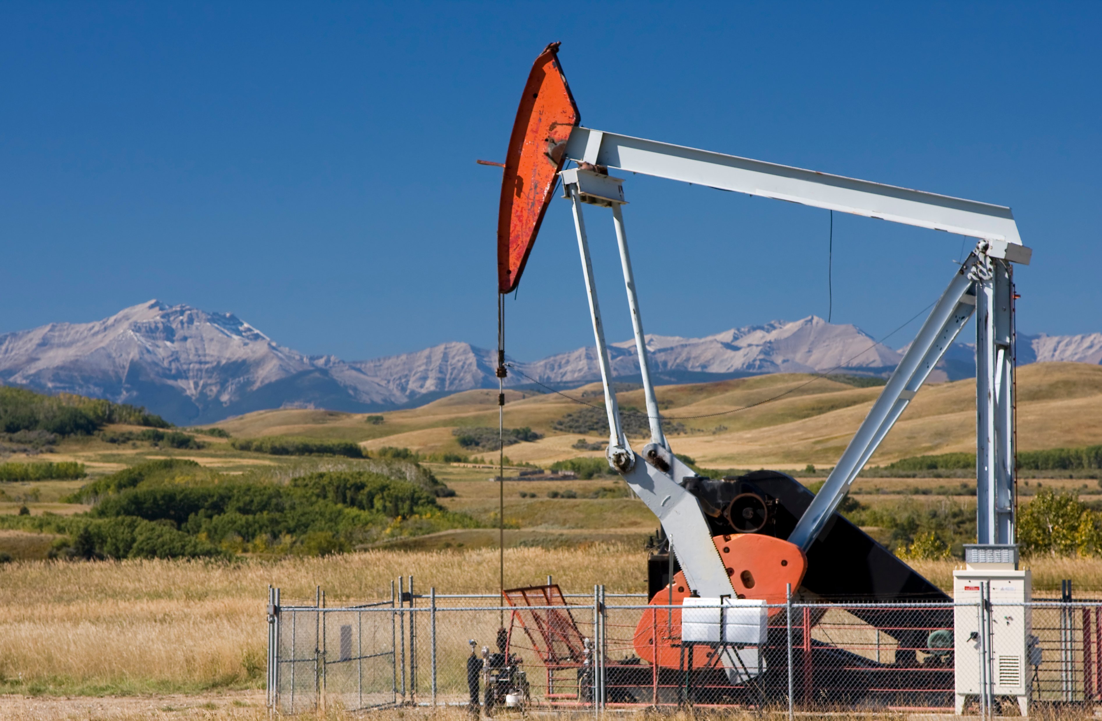 An oil pump with mountains in the background.