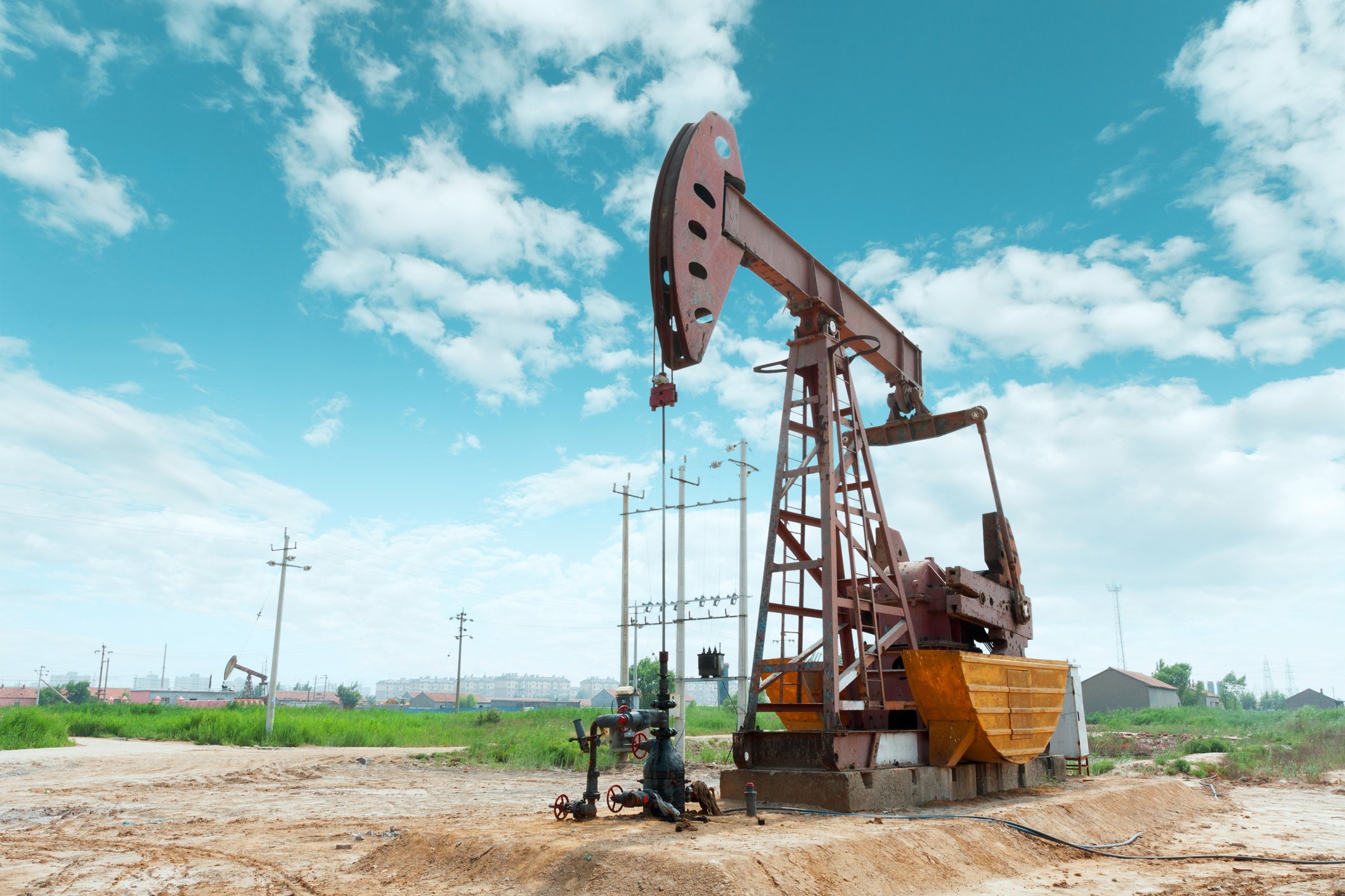 An oil pump with a blue sky behind it.