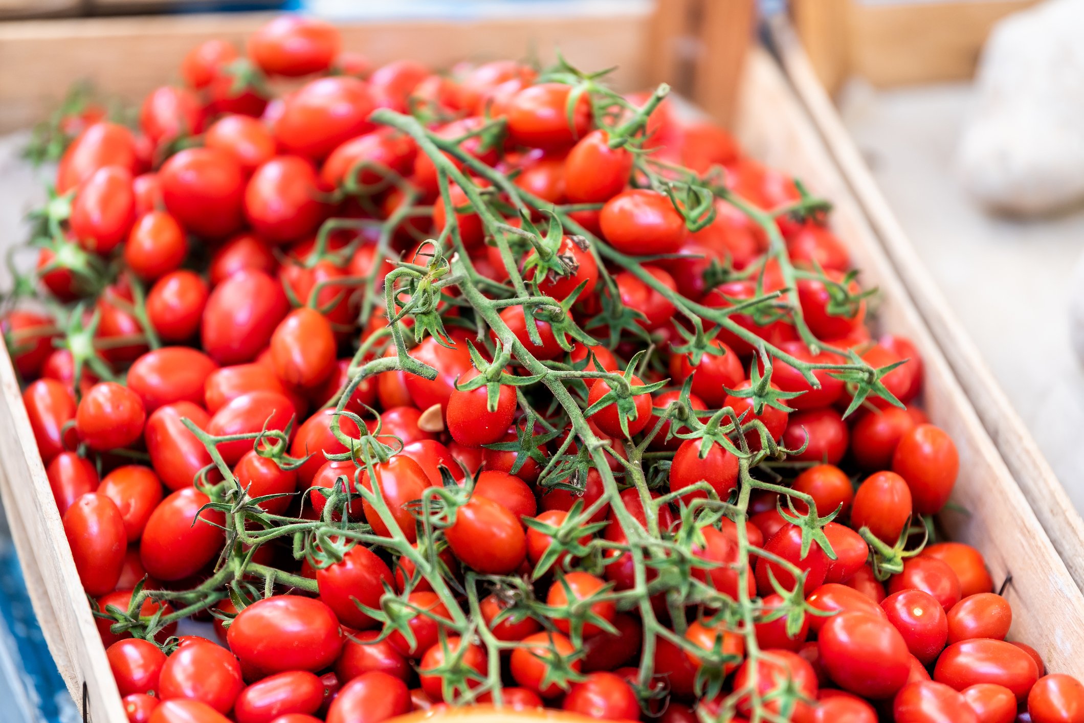 A close up of tomatoes in a wooden crate.