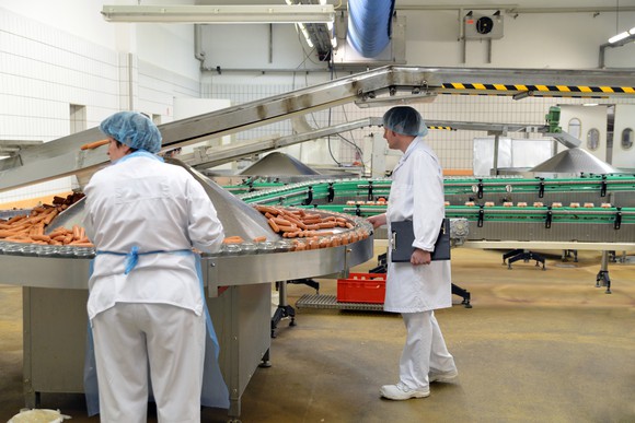Two employees in hairnets in a food manufacturing facility