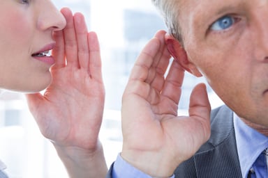 Woman whispering to man