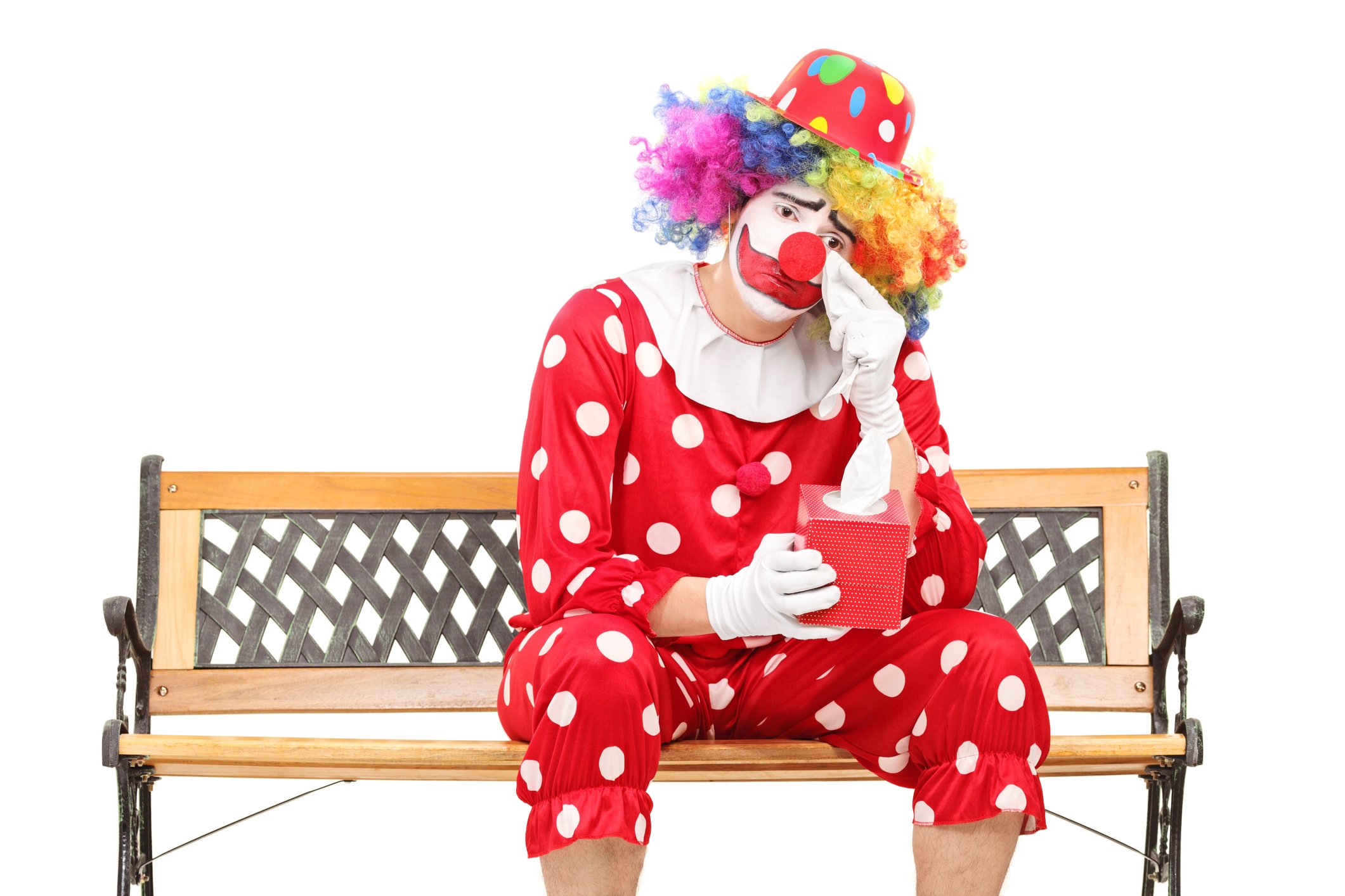 Sad clown sitting on a bench.