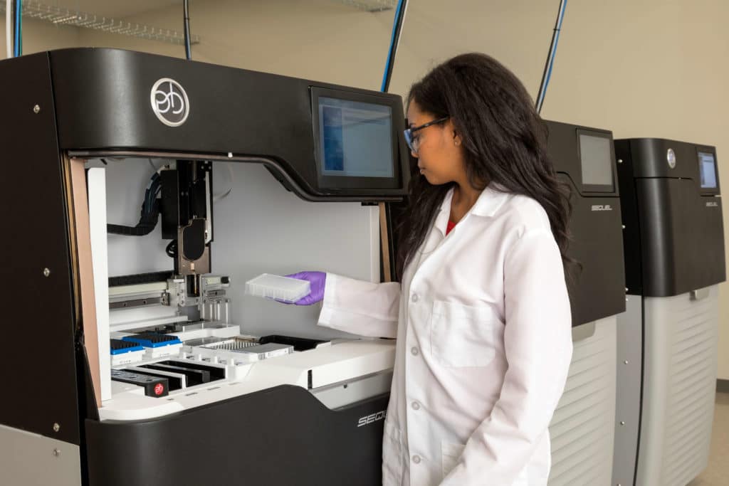 Woman in lab coat using PacBio's Sequel system.