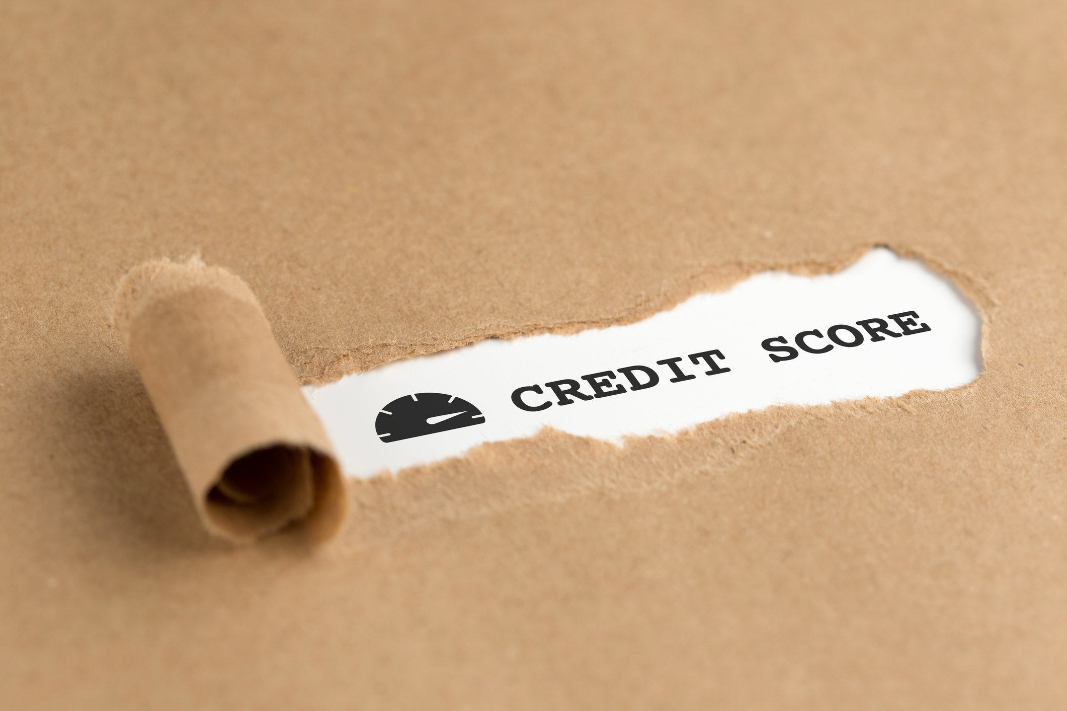 Paper being torn to reveal text that says Credit Score.