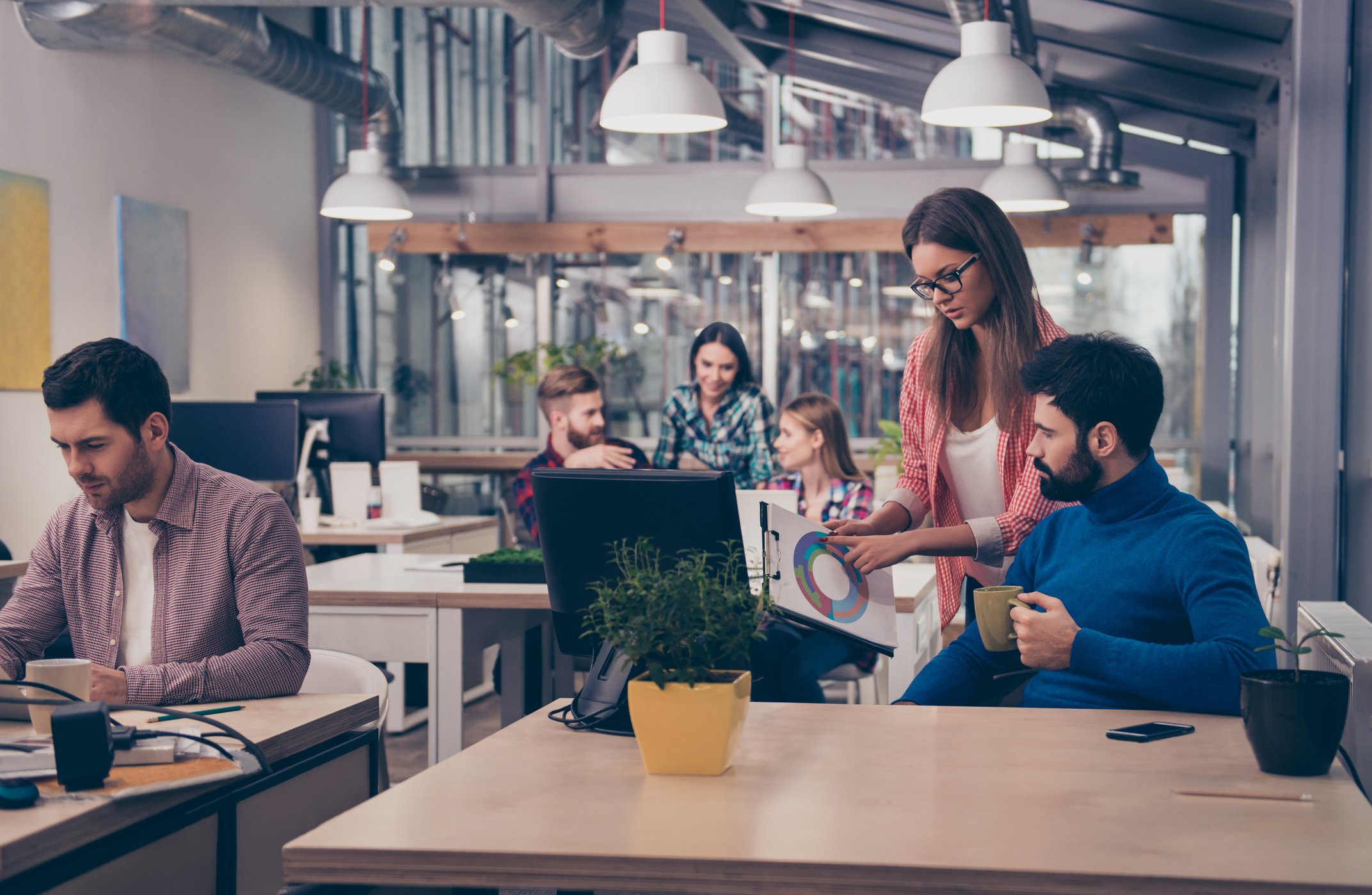 Workers interact in a shared office.