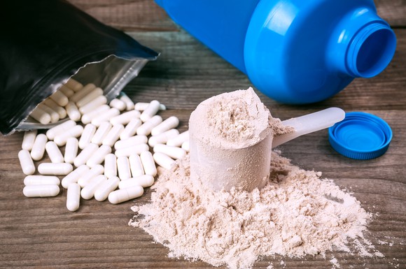 Nutritional supplement pills and powder on a table.