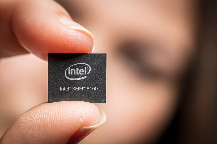 A person holding a chip that says Intel XMM 8160.