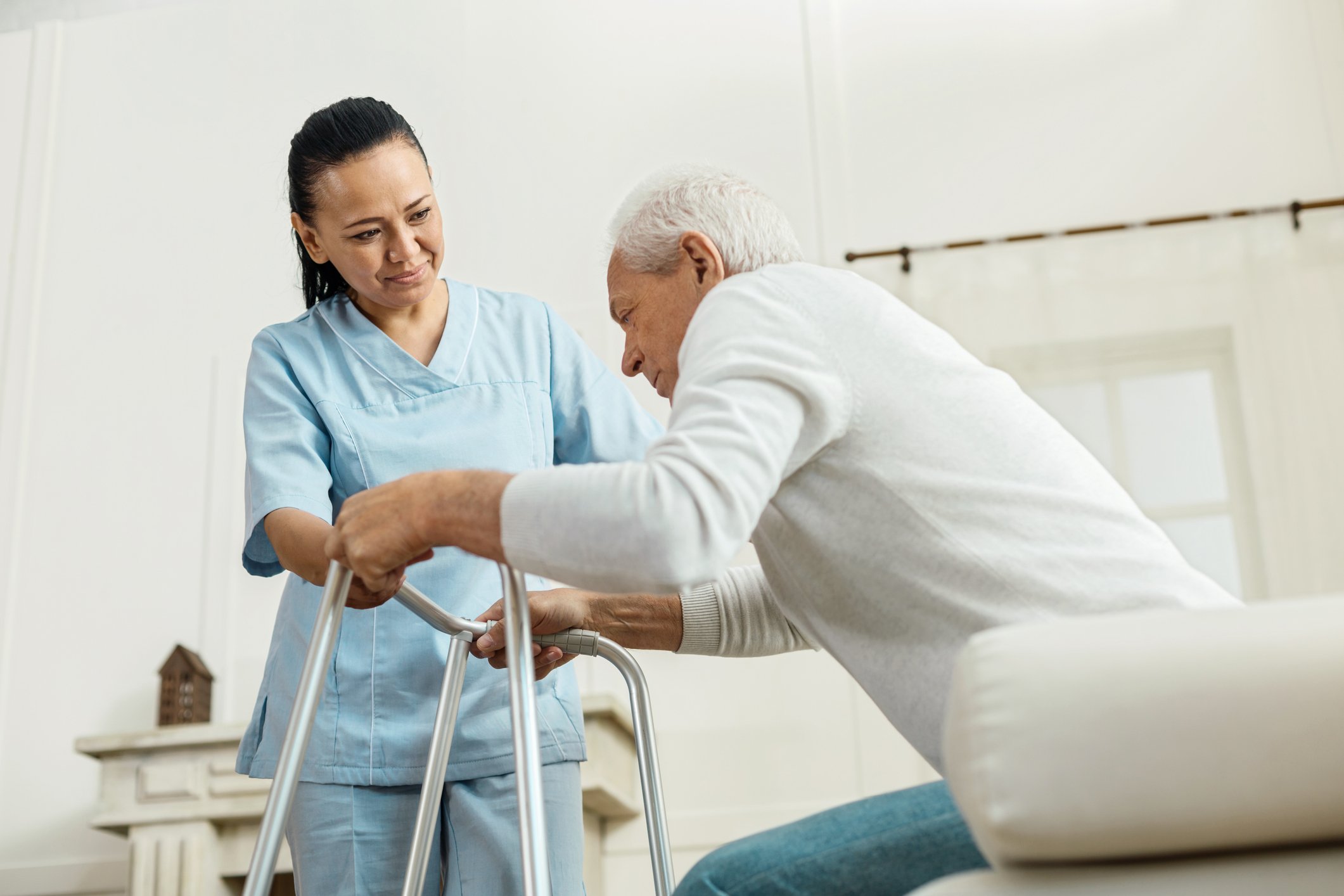 Nurse assisting an elderly patient in standing up.