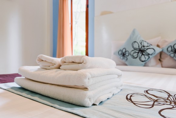 Towels folded on bedspread.