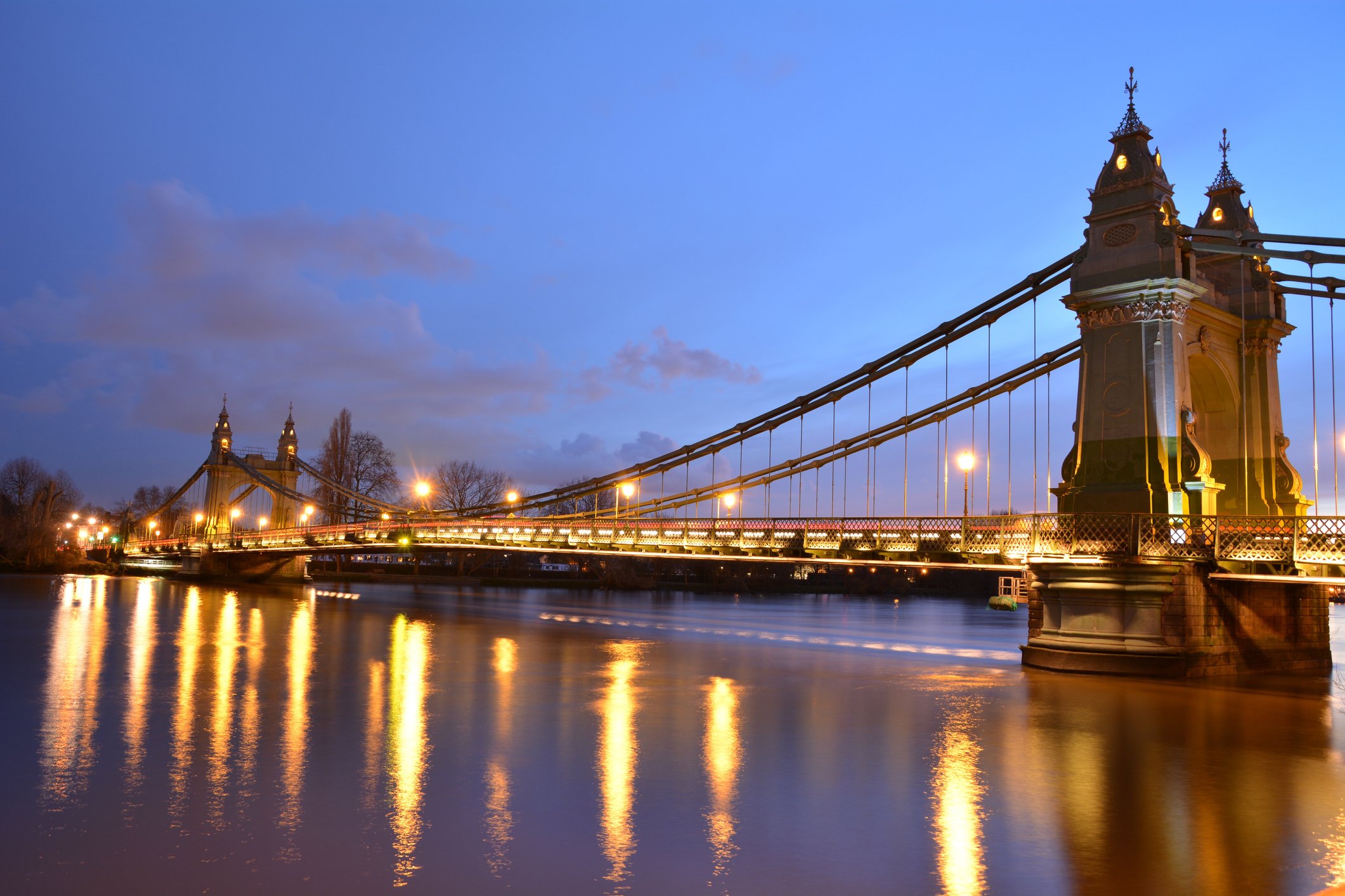 View of suspension bridge over the river Thames at dusk.