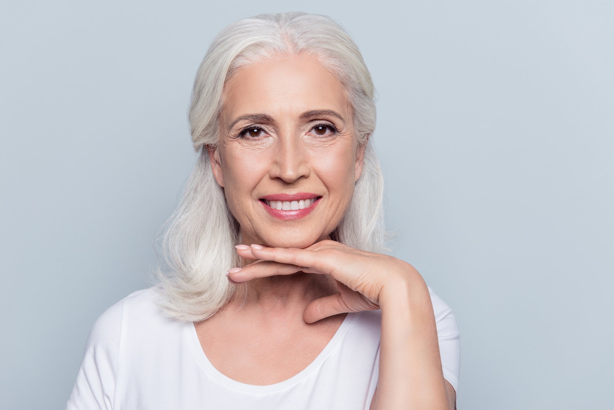 Smiling older woman against a gray background