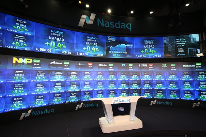 A Nasdaq television studio with the digital quote board in the background.