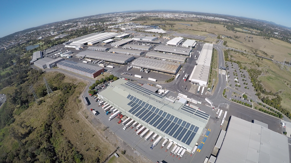 Aerial view of production facility with extensive solar panel arrays on roofs of multiple buildings