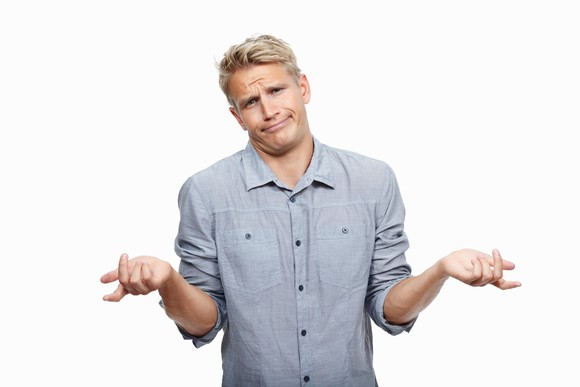 Shrugging man with a smirk on his face. 