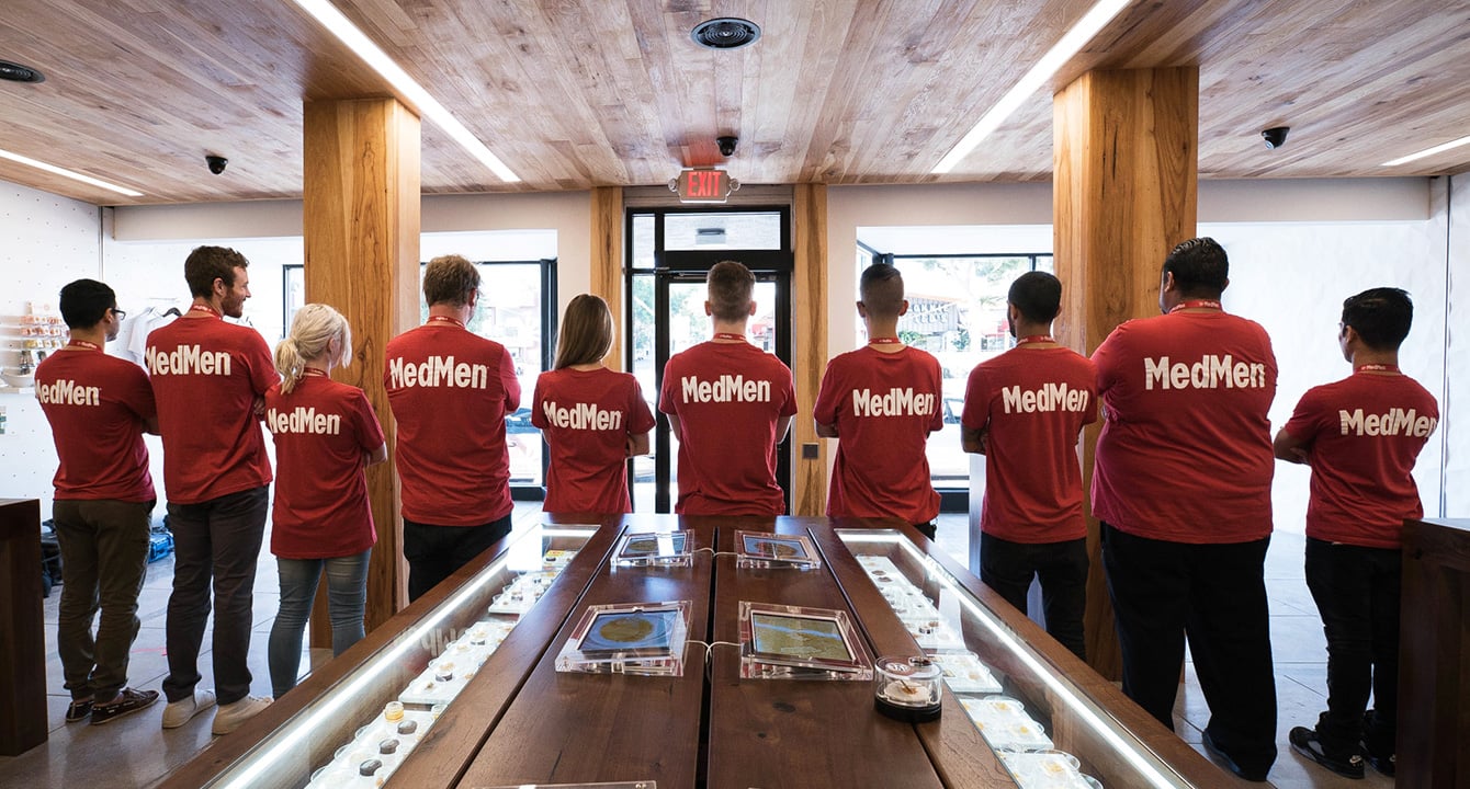 MedMen employees in store wearing red T-shirts with the company name on the back