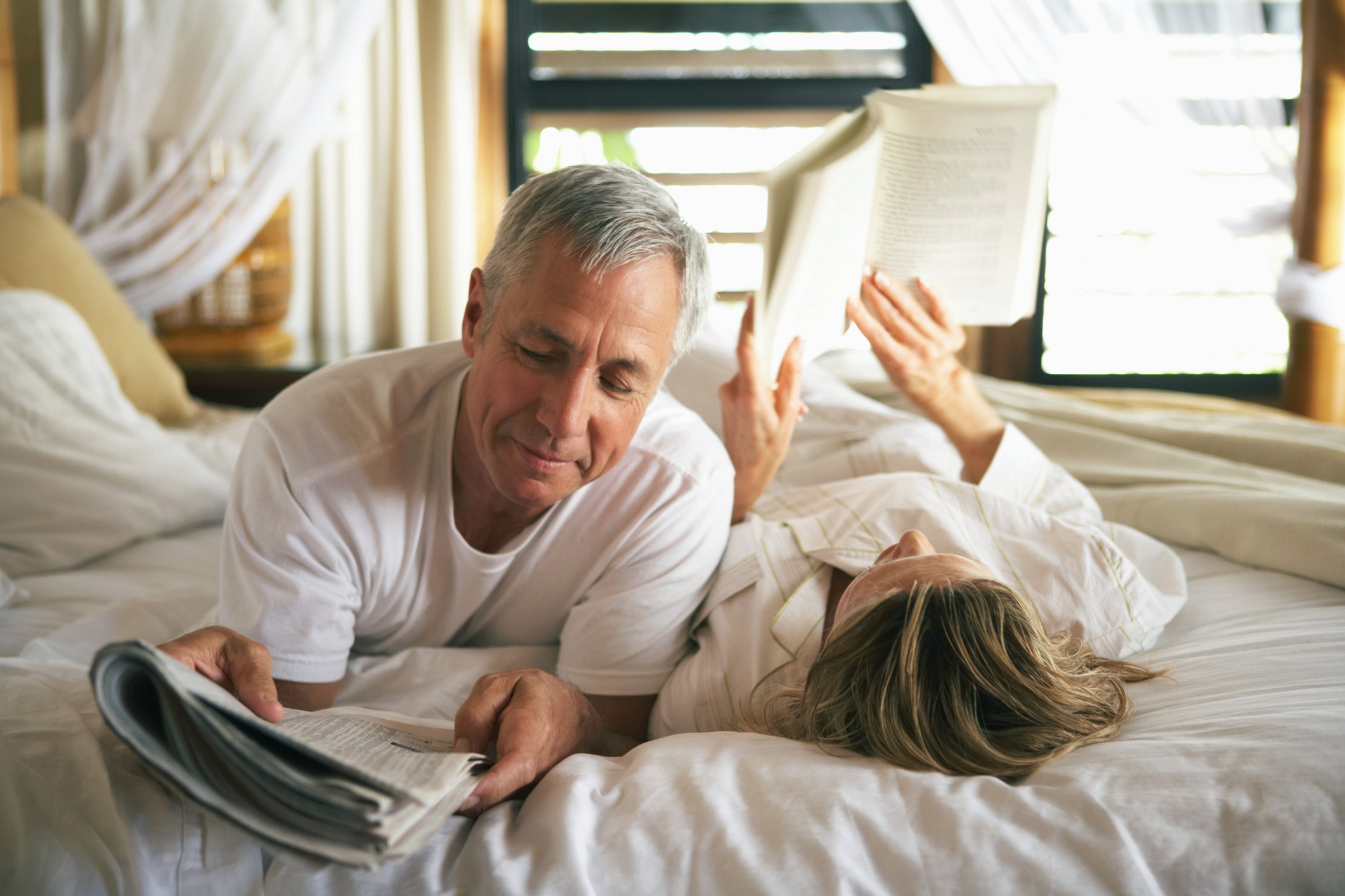 A senior couple reading in bed.