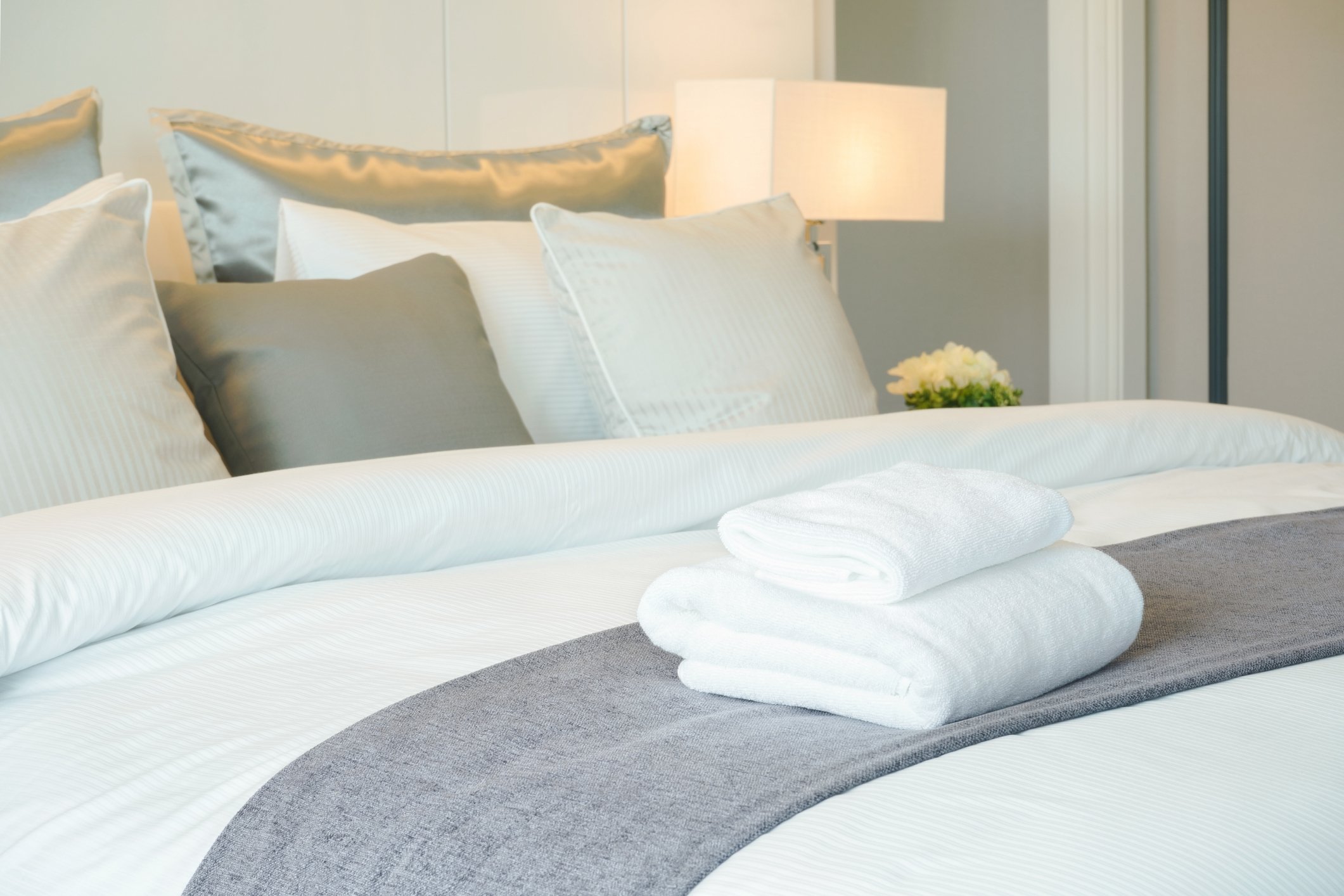 Hotel room with towels on the bed. 