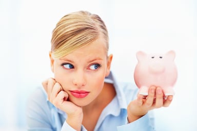 Worried Millennial Woman Holding Piggy Bank Getty